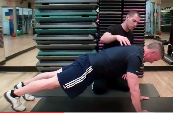 Dr. Brent Brookbush instructs personal trainer, Mike Tierney on correct form for a traditional push-up.