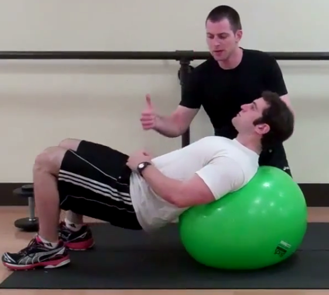 Dr. Brookbush instructs personal trainer, Vinnie Laspina, on how to properly perform a stability ball glute bridge.