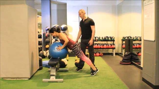 Dr. Brookbush instructs Melissa Ruiz on how to regress a stability ball push-up.